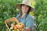 Garden educator Callie Works-Leary holding a basket of heirloom tomatoes in her DFW North Texas garden.